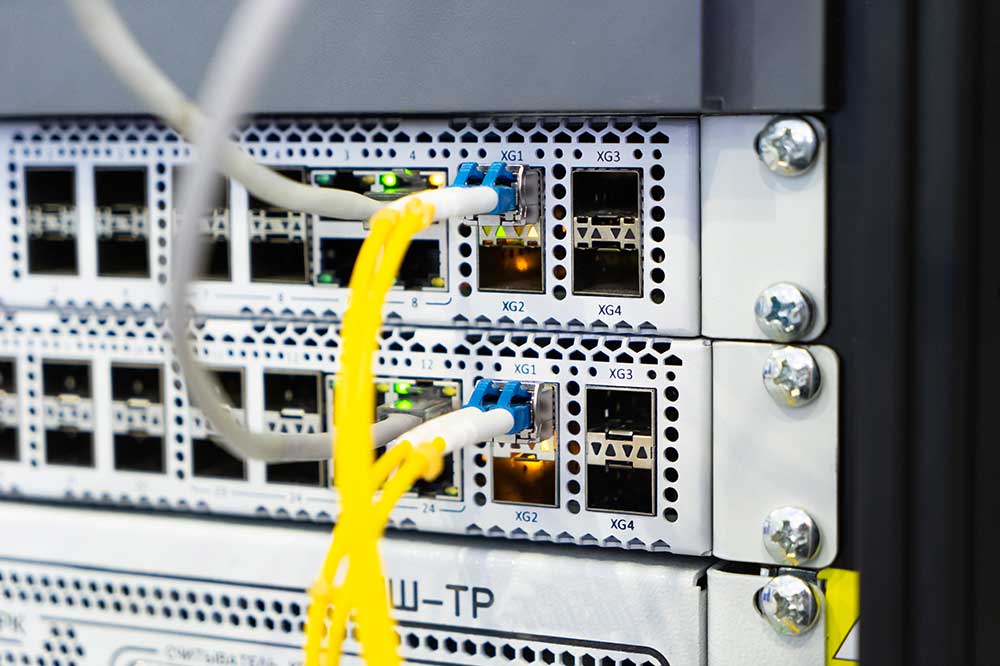 Serwer z podłączonymi kablami światłowodowymi i ethernetowymi.