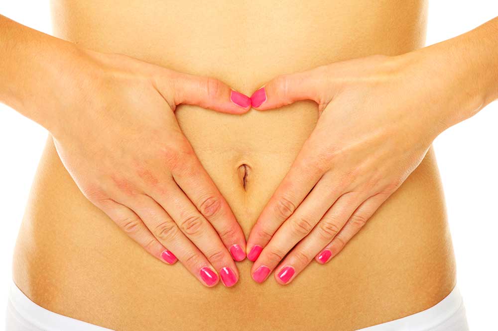 Dłonie ułożone w kształt serca na brzuchu.
