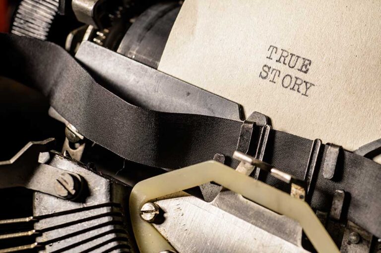 Zbliżenie maszyny do pisania z kartką papieru i napisem "TRUE STORY".