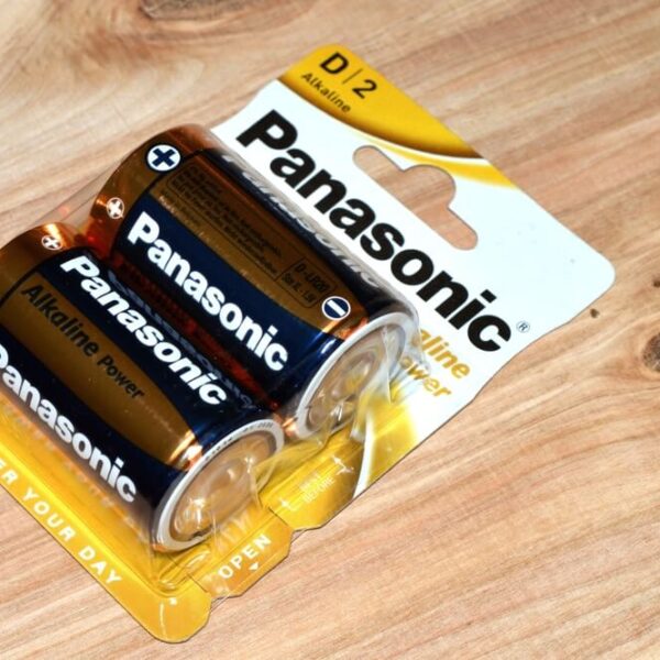 Opakowanie dwóch baterii alkalicznych Panasonic D/2 na drewnianym tle.