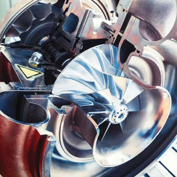 Przekrój wnętrza turbiny, ukazujący wirnik i elementy mechaniczne w środku urządzenia.